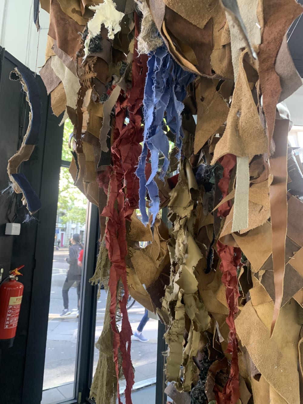 Pieces of coloured leather hanging from the ceiling