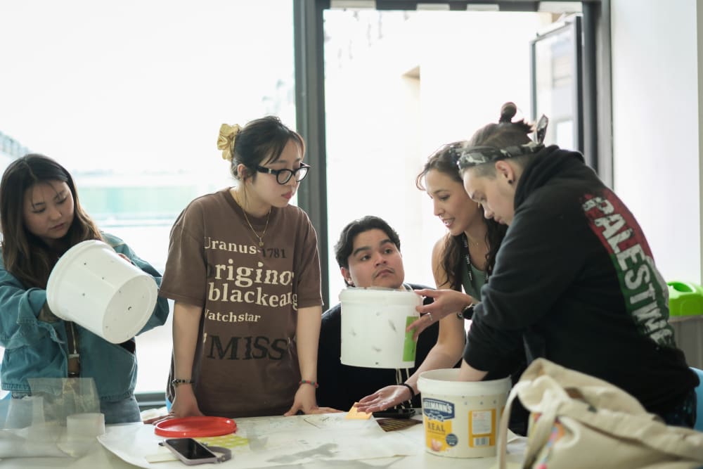 Participants at Soil Stories workshop making wormeries out of plastic buckets