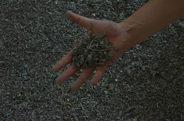 A hand holding gravel taken from the art installation