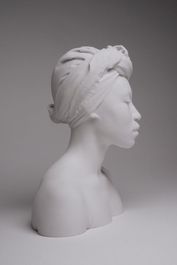 A side profile sculpture of a woman's head and shoulders.