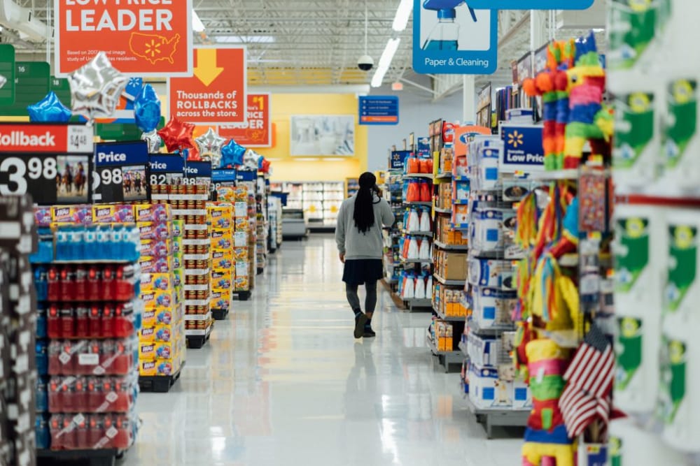 a supermarket with a person walking down the middle of the aisle