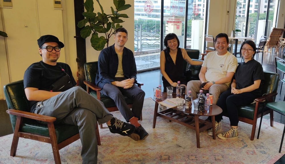 Five people sat smiling into the camera