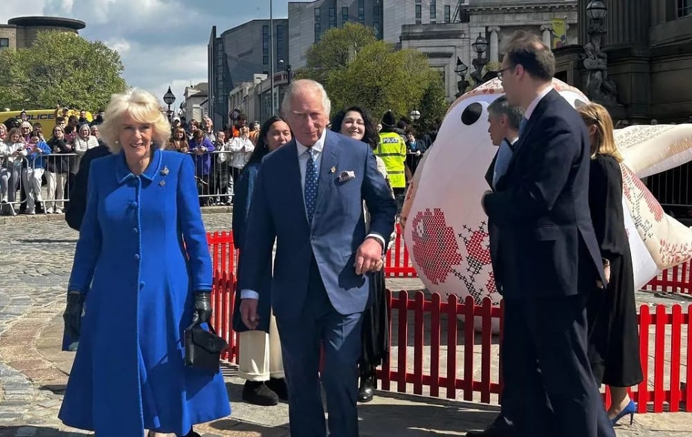 king and queen walking past a public art work