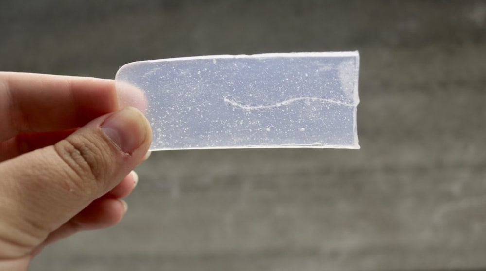 A hand holding a glass slide