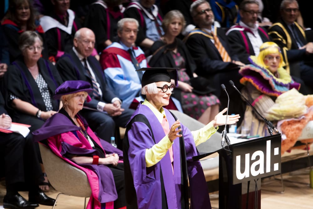 Woman in gown making speech during graduation