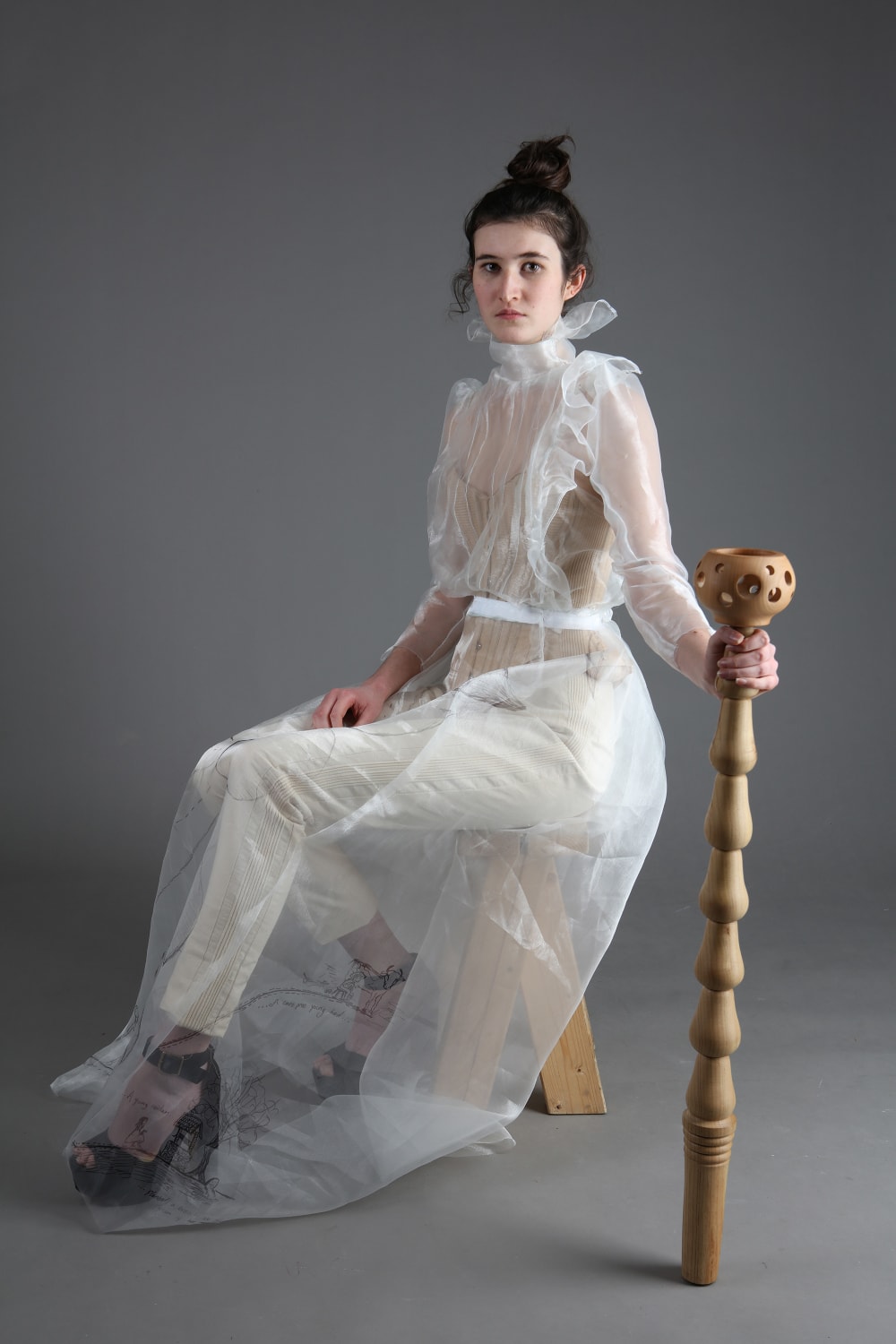Model wearing Evie's witch costume and holding wooden 'magic' tool