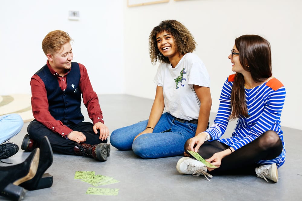 Students playing card games and laughing