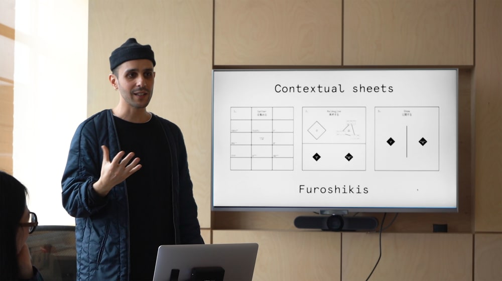 Man talking and standing by whiteboard 