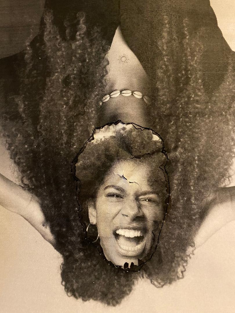 Black and white image of an upside down body with a head stuck on top