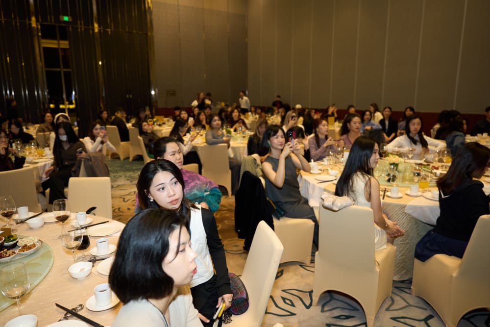 Wide shot of the room, guests all looking towards the front of the room