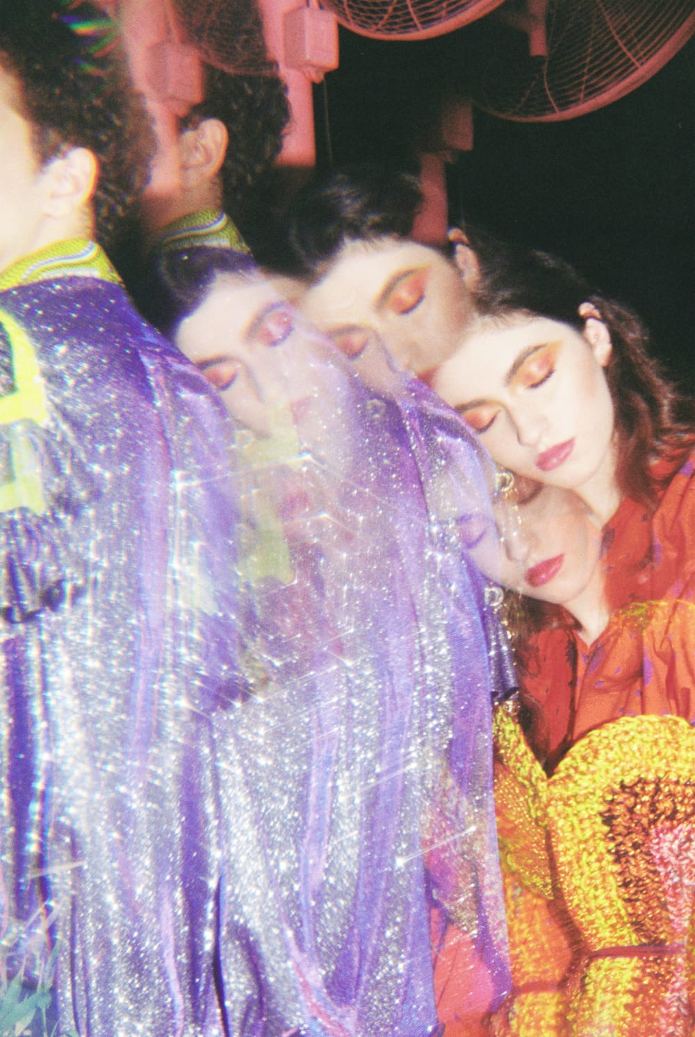 an abstract portrait of a person with red eye shadow, leaning on another persons back