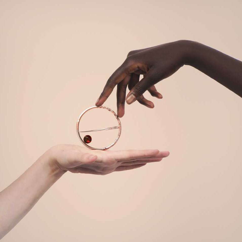 Two hands touching circular jewellery
