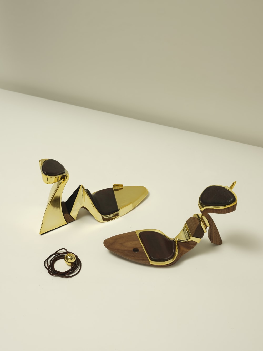 Pair of shoes made out of wood and a gold coloured material, with geometric shapes