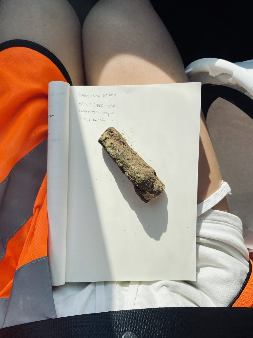 Rock on top of a book sat on a person's lap
