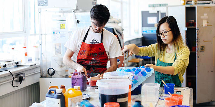 Two students preparing specialist dyes for textile printing.