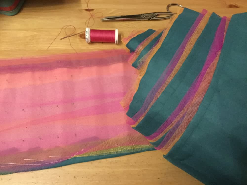 Layers of pink, yellow and teal fabric laid on top of eachother