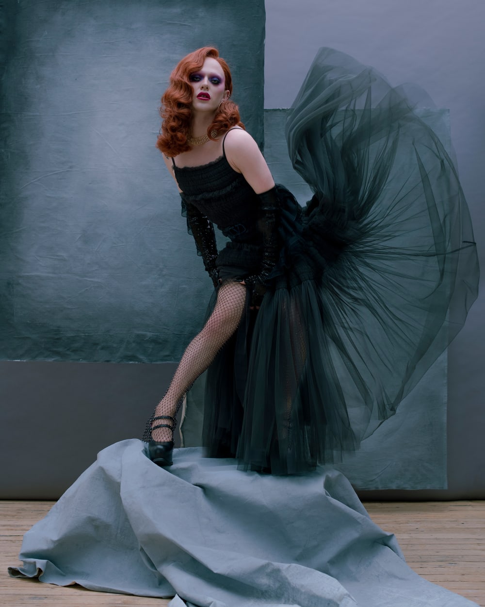 Drag queen Bimini Bon Boulash posing in a dark green tulle dress and auburn hair