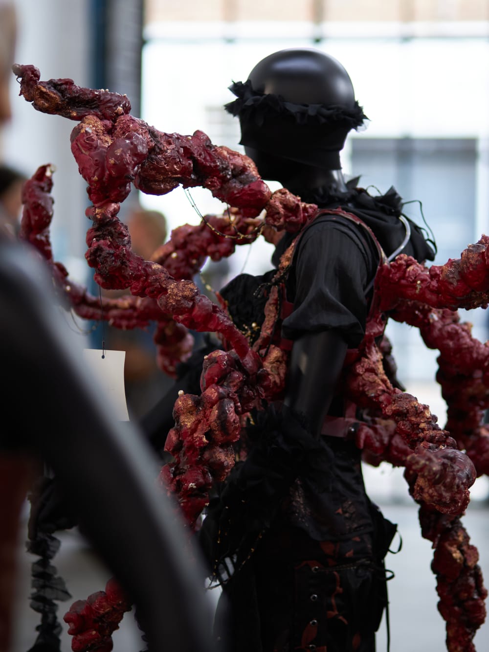 Side profile image of mannequin wearing black and red costume