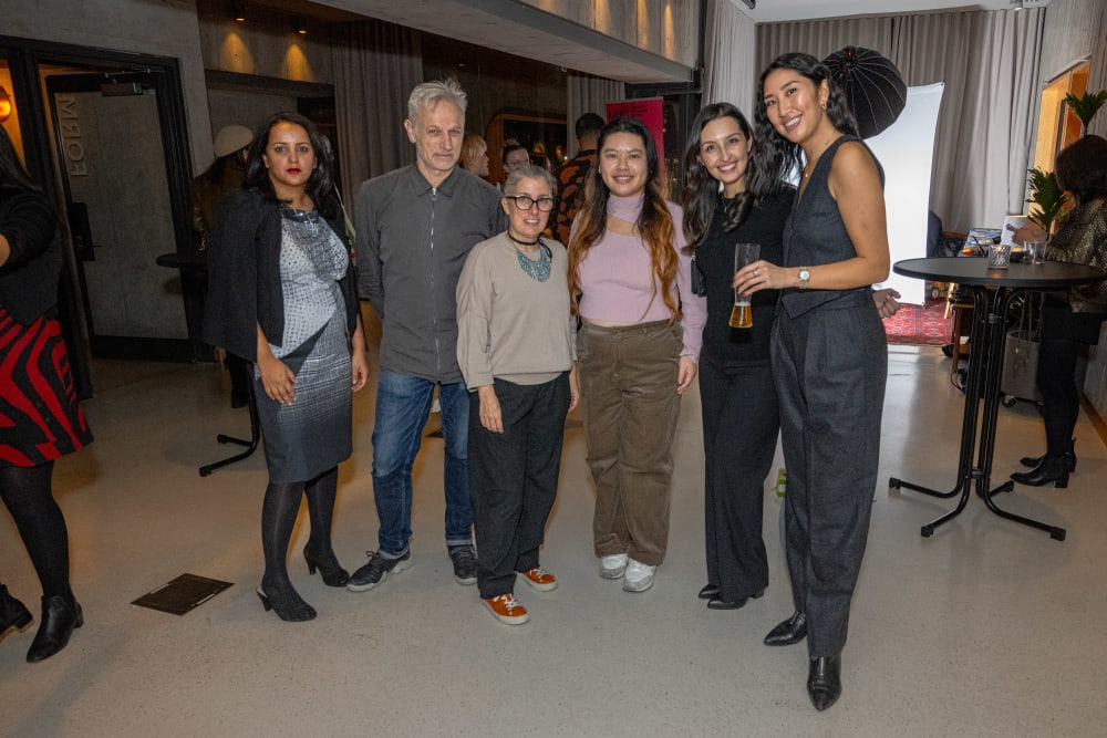 Six guests from the event smiling to the camera