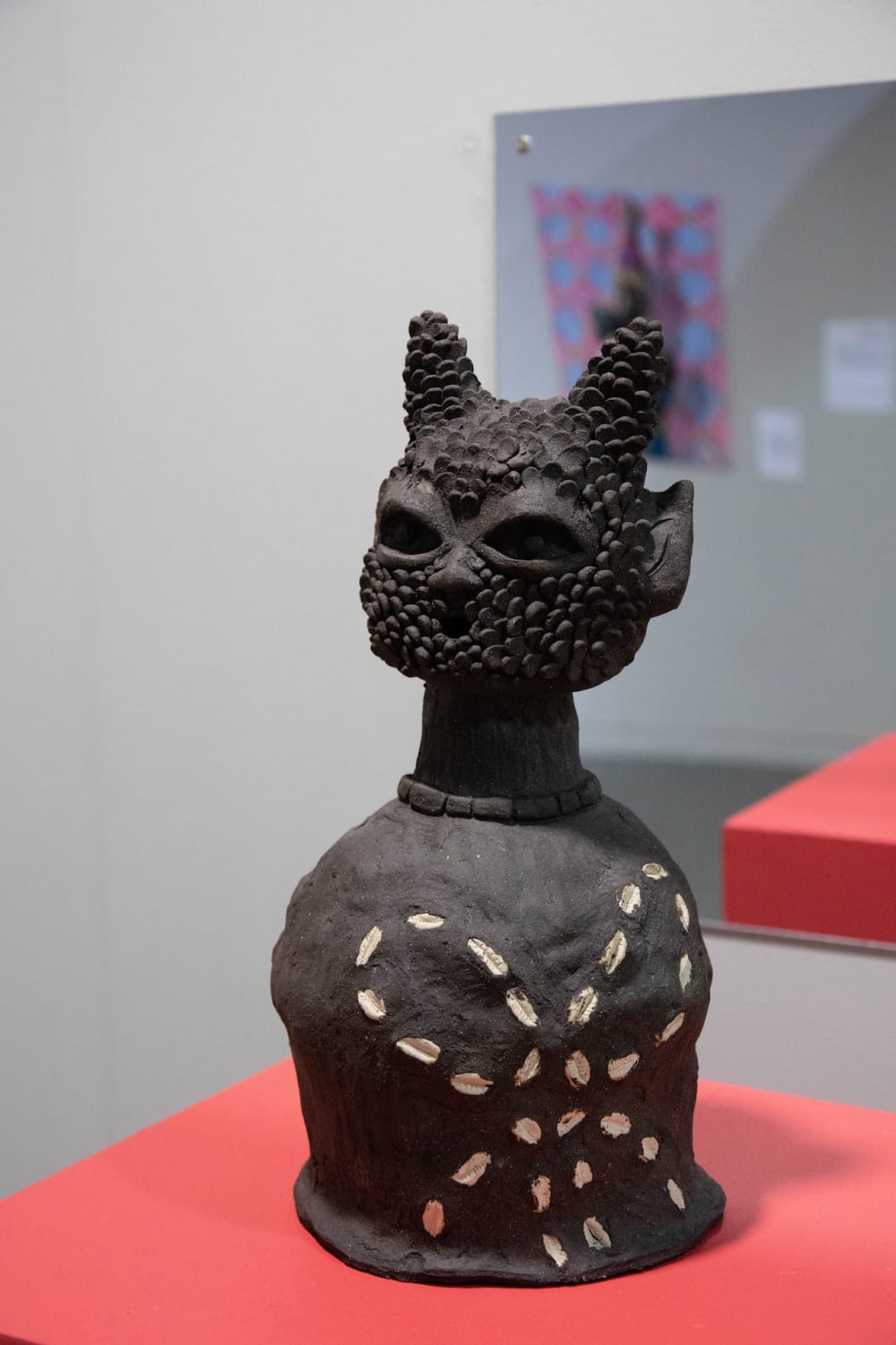 Brown art object on red stand