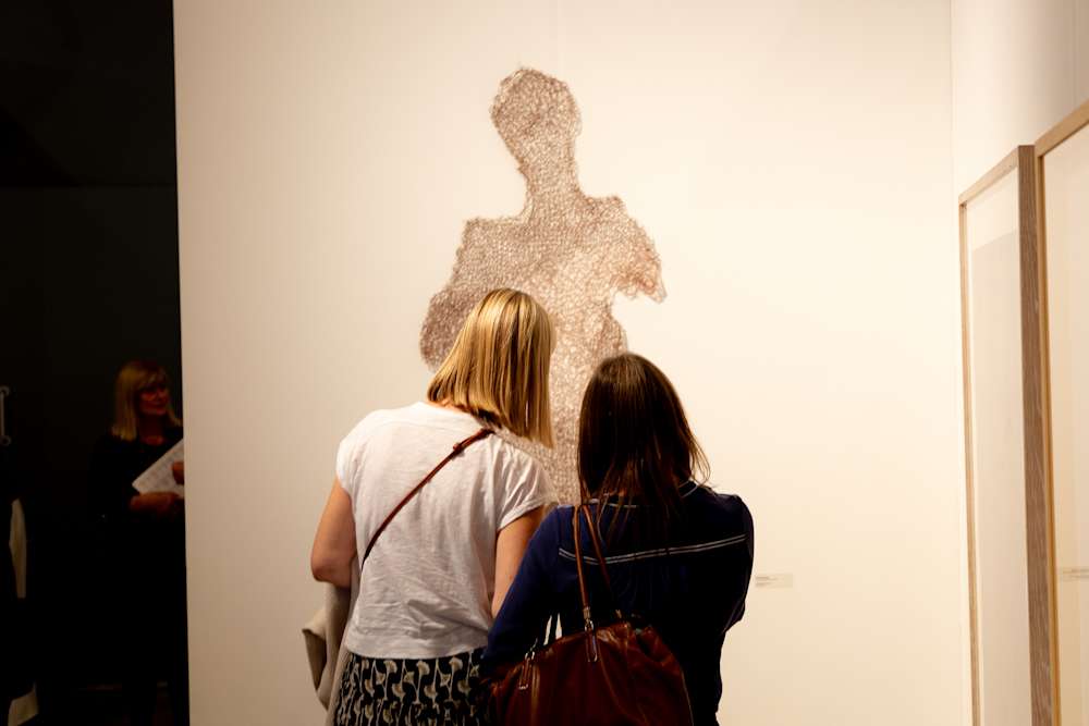 People looking at the winning work at the Trinity Buoy Wharf Drawing Prize 2026