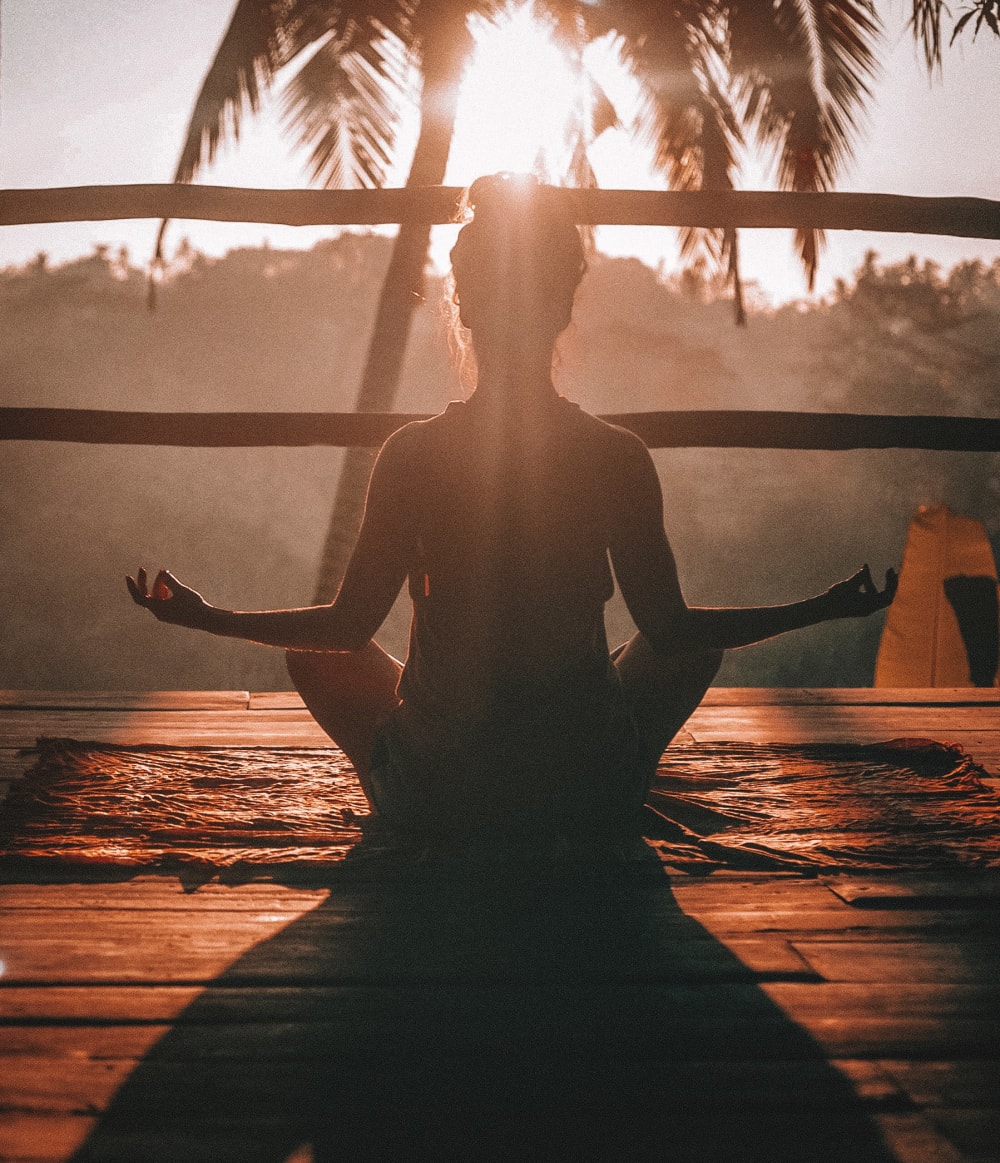 Woman meditating on a wooden balcony