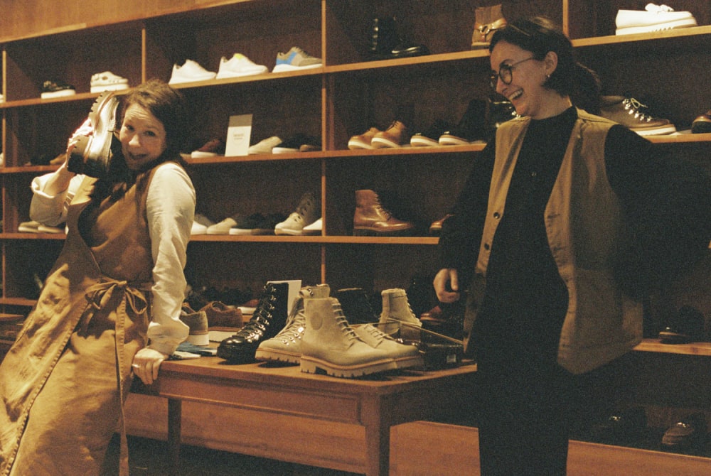 Two women smiling and playing with shoes