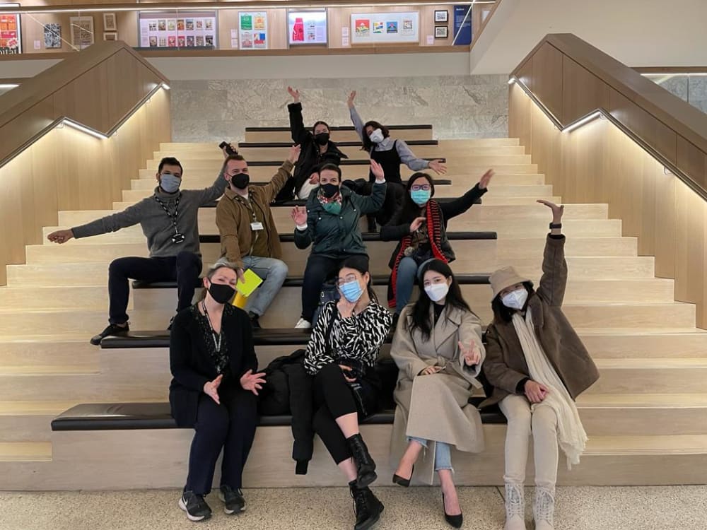 postgrad students waving at Design Museumon steps