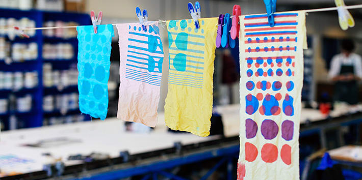 A series of student experiments with textile print hanging to dry.