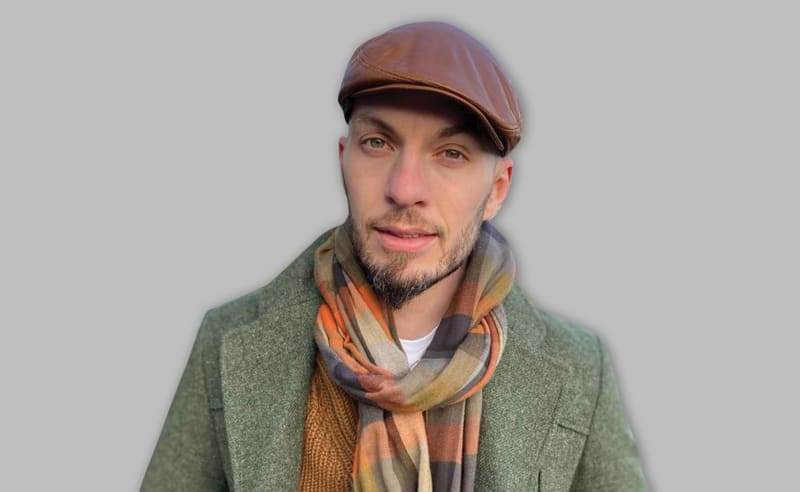 Portrait photograph of a man wearing a coat and hat.