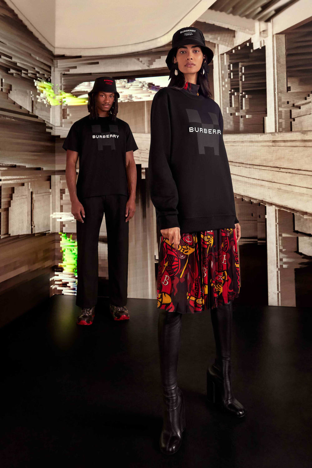 Two individuals standing in front of a digitally created background wearing black Burberry tshirts.
