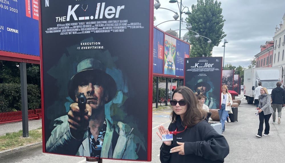Sonya Vseliubska with a poster advertising the David Fincher film The Killer