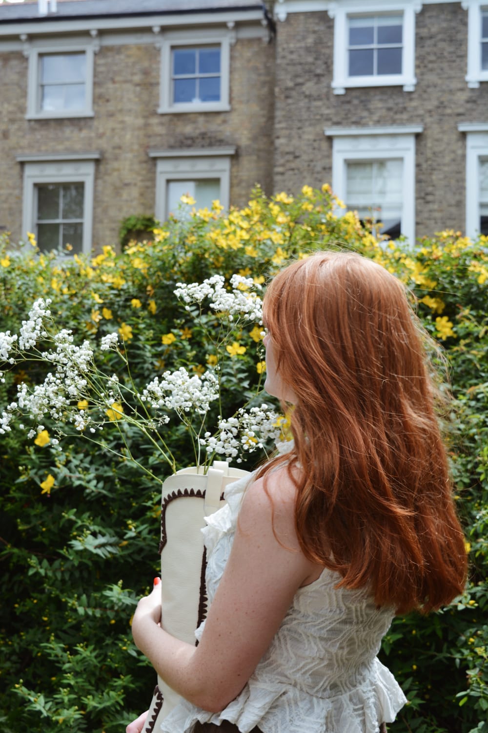 Therese Frank model holding ANNA boot with white flowers inside