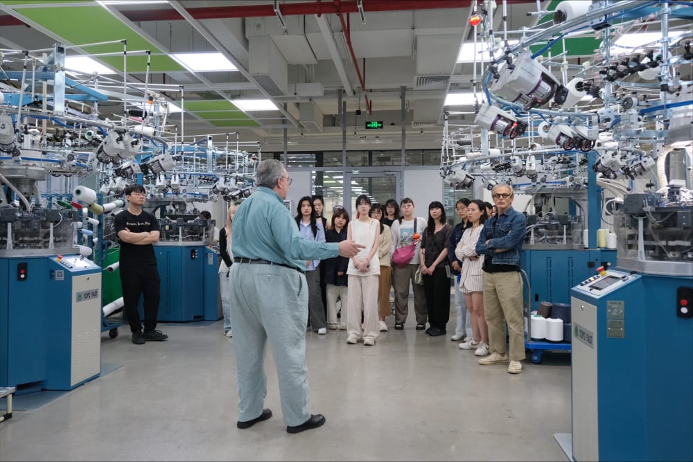 Group of students being led a round a knitwear factory.