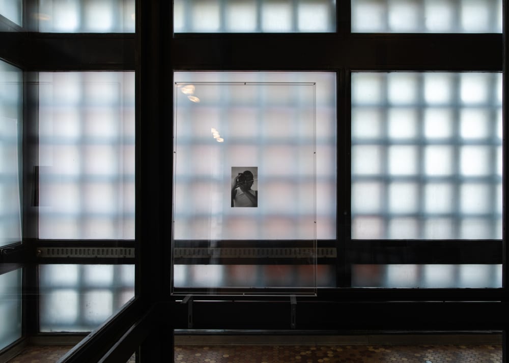 Room of translucent bricks with a small black and white photo in the middle. 