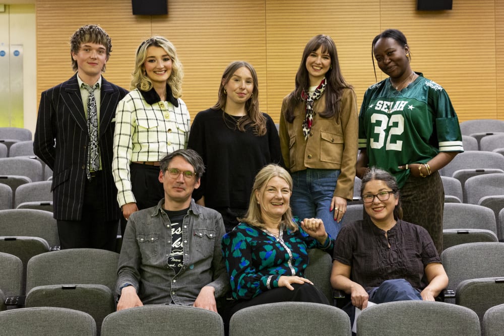 Panellists standing and smiling to the camera
