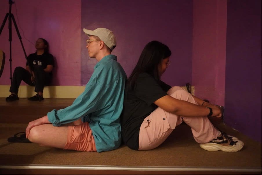 two people sitting back-to-back