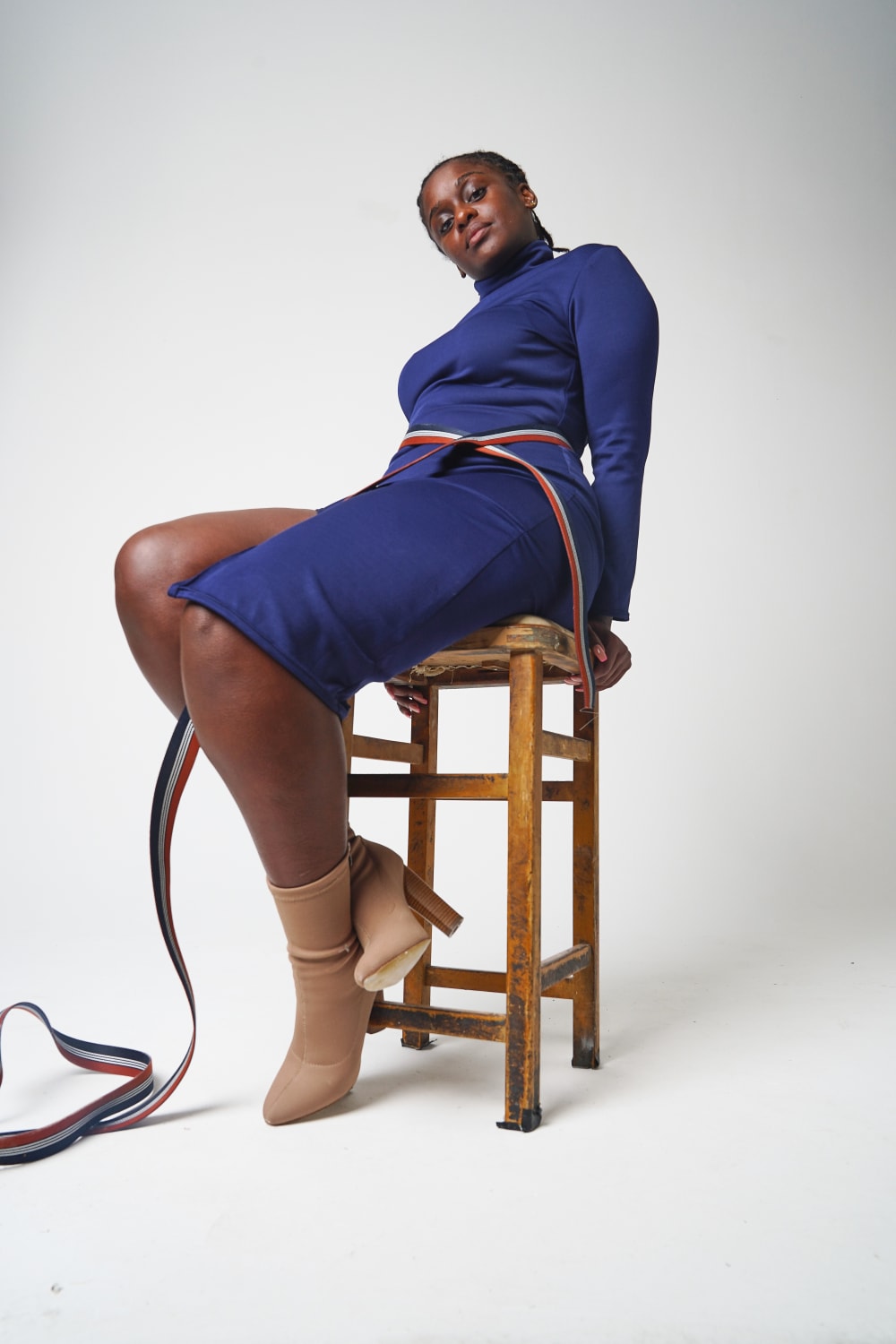 Woman sitting on a bench with a blue dress and light brown boots