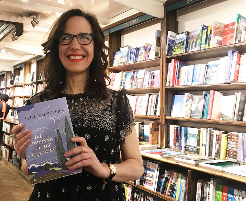Elise Valmorbida in bookshop holding her book.