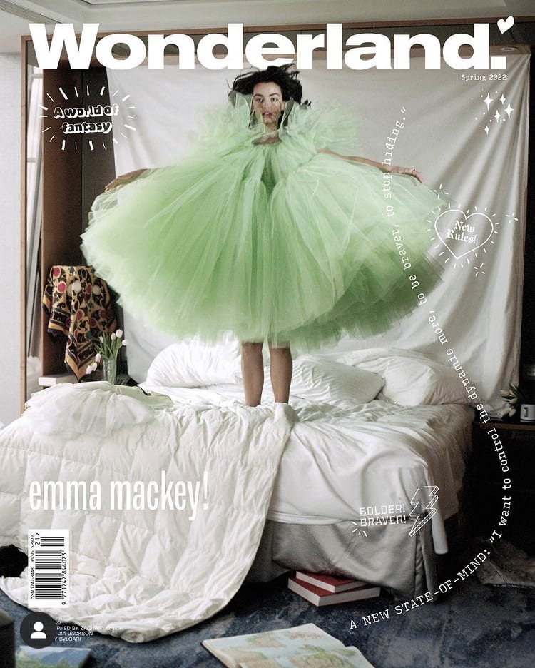 Cover of Wonderland magazine with Emma Mackey in a puffy green tulle dress standing on the bed in a bedroom set designed by Hugo