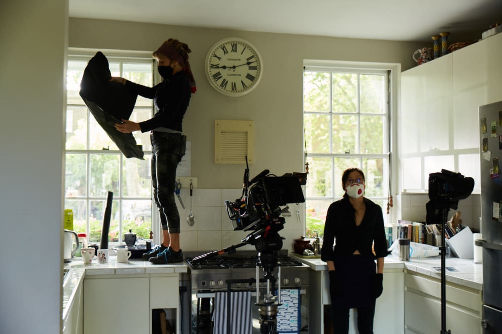 Photo of a film set. There's big windows with cameras set up