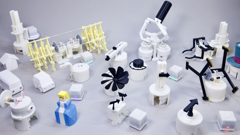 A selection of toio robots laid out across a table 