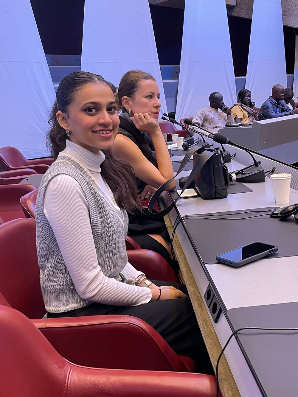Photograph of two people sitting in a meeting venue.