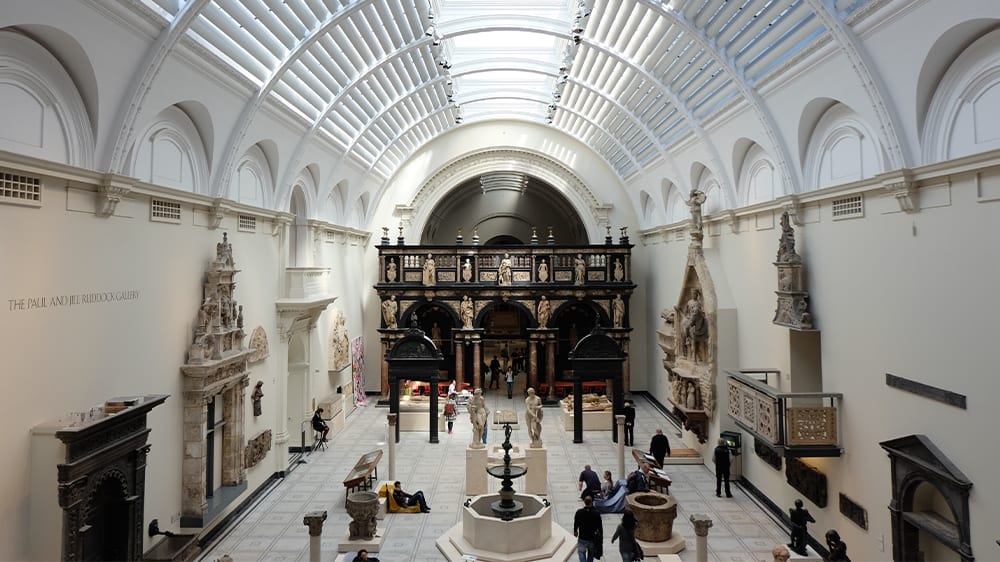 A large light filled hall at the V&A museum displays marble statues.
