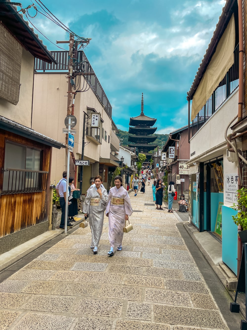 two geisha walking down a street