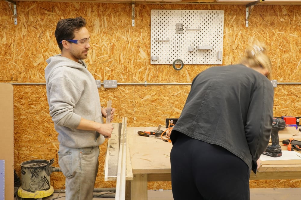 2 people working in a workshop. 