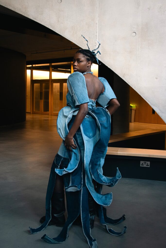 Person in dress made of denim looking at camera