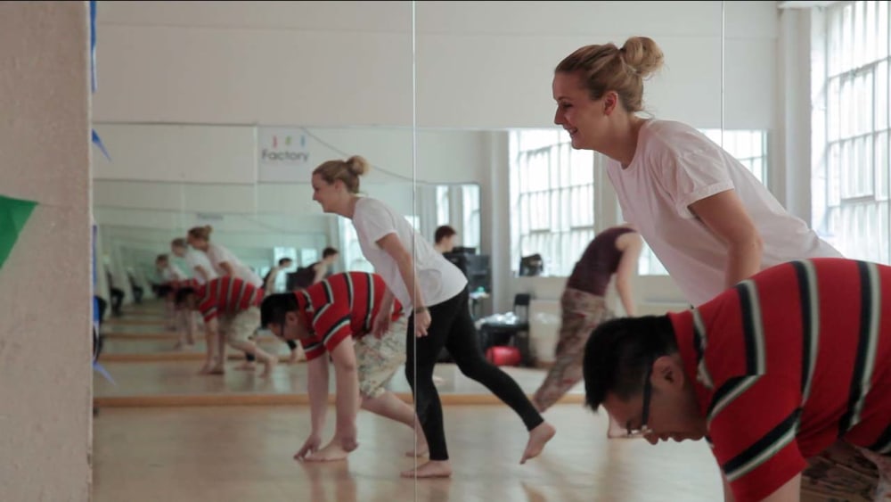 A woman and a man reflected multiple times in a dance studio mirror