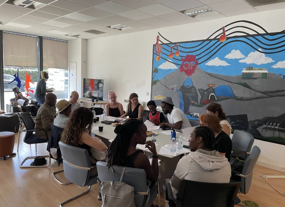 People sitting at a table reading a script