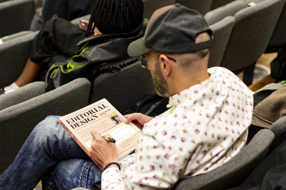Man sitting with a copy of Editorial Design on his lap